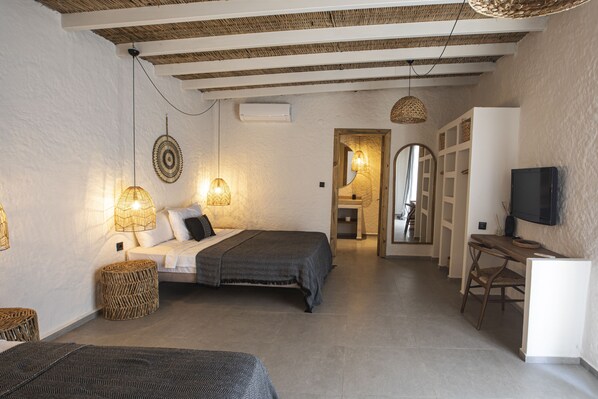 A bedroom with a bed, bedside lamps, a TV, and a desk. - Art Alacati (Cesme)