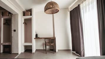 A modern room with a desk, chair, and a hanging woven light fixture.