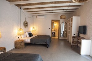 A bedroom with a bed, bedside lamps, a TV, and a small desk area. - Art Alacati (Cesme)