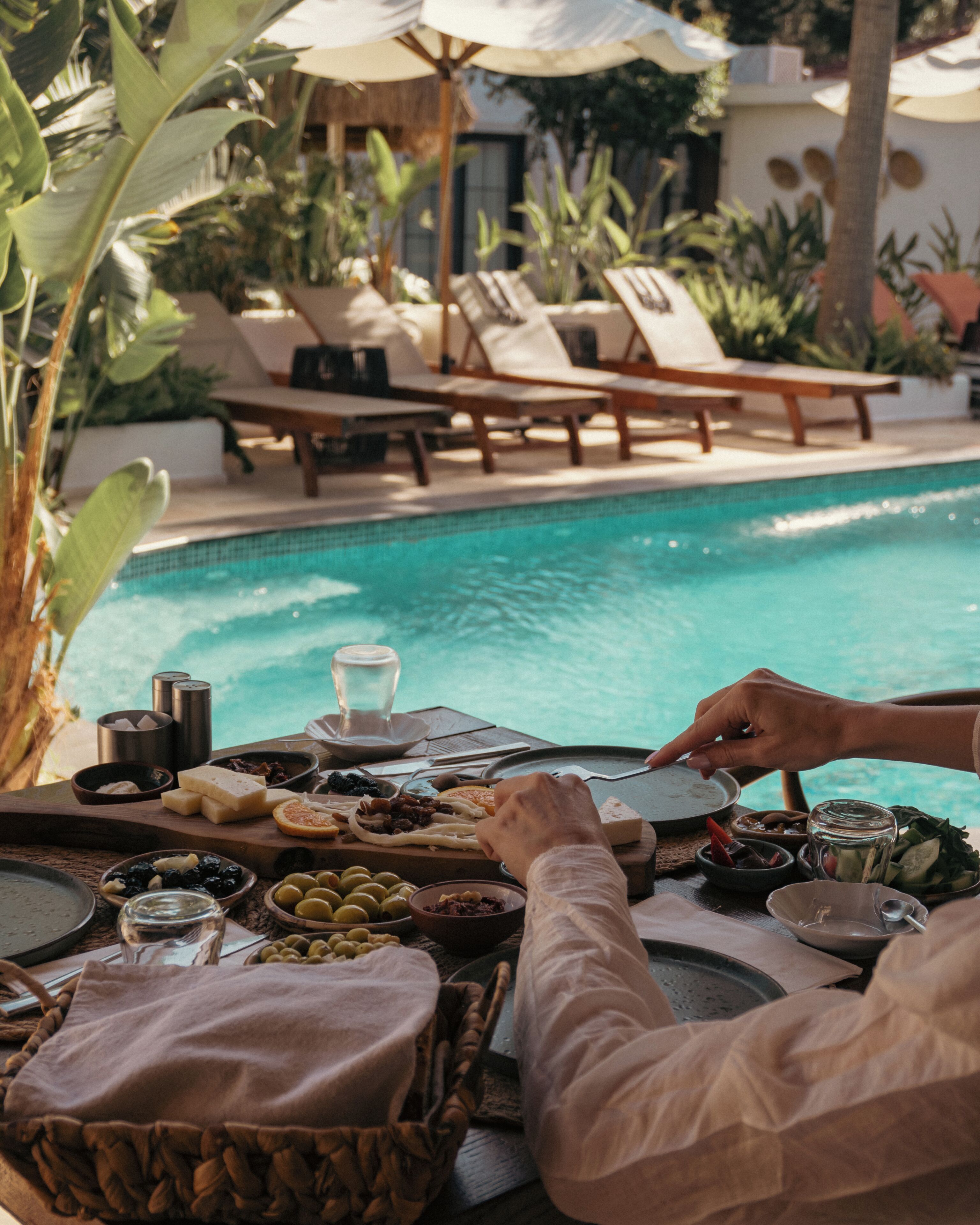 Ein Essbereich am Pool mit Liegestühlen und einem Buffet.