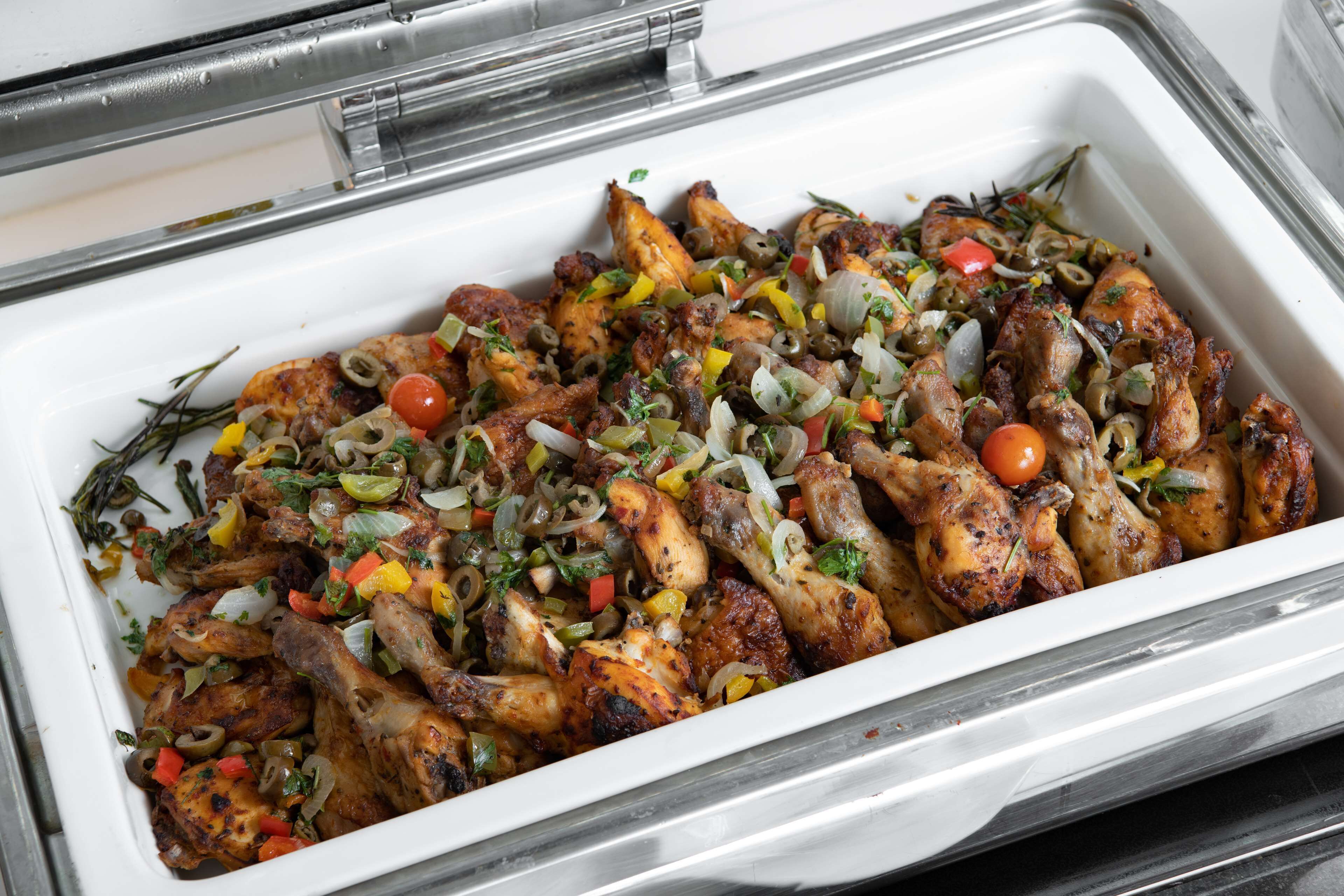 A tray of roasted chicken with vegetables.