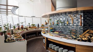 Een moderne keuken met een gebogen aanrecht waarop verschillende etenswaren staan en een betegelde spatwand.