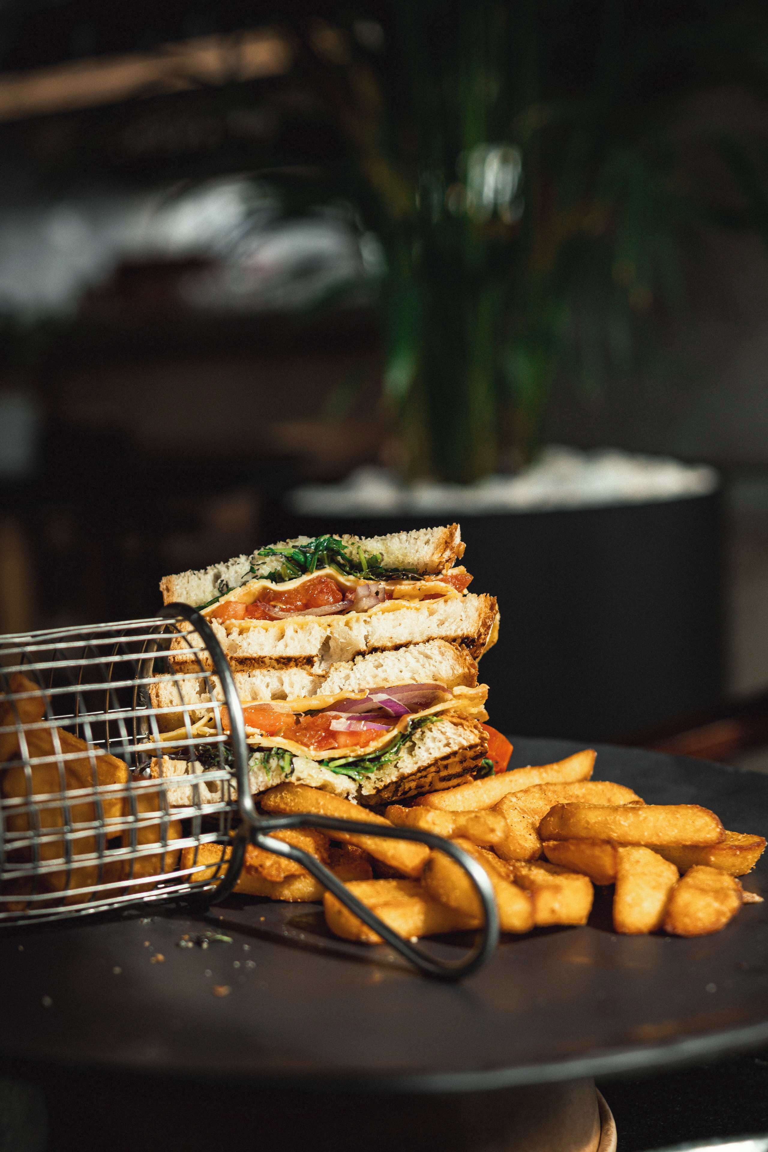 Un montón de sándwiches y una cesta de papas fritas en un plato.