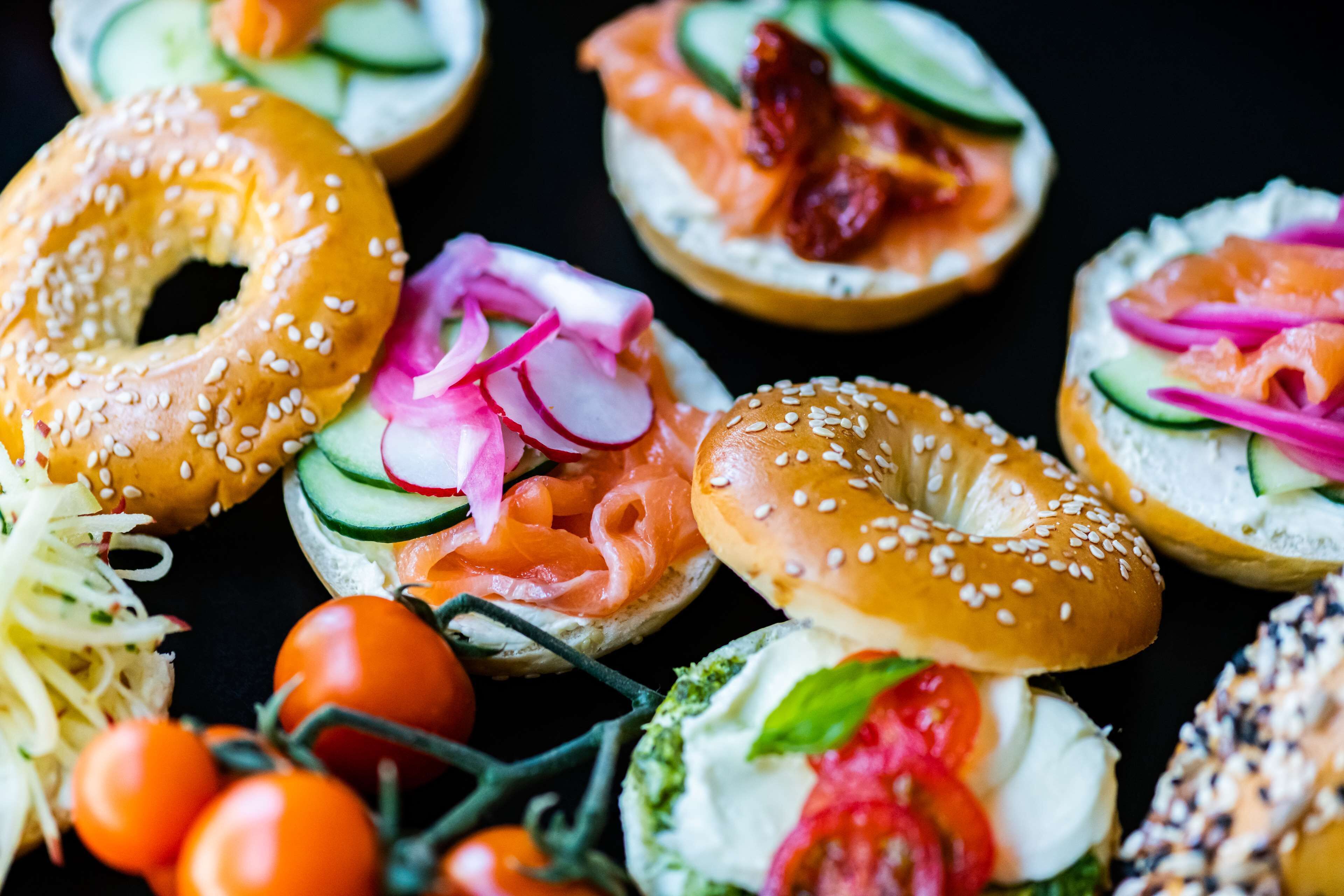 Variedad de bagels con diferentes ingredientes como salmón ahumado, queso crema y verduras.