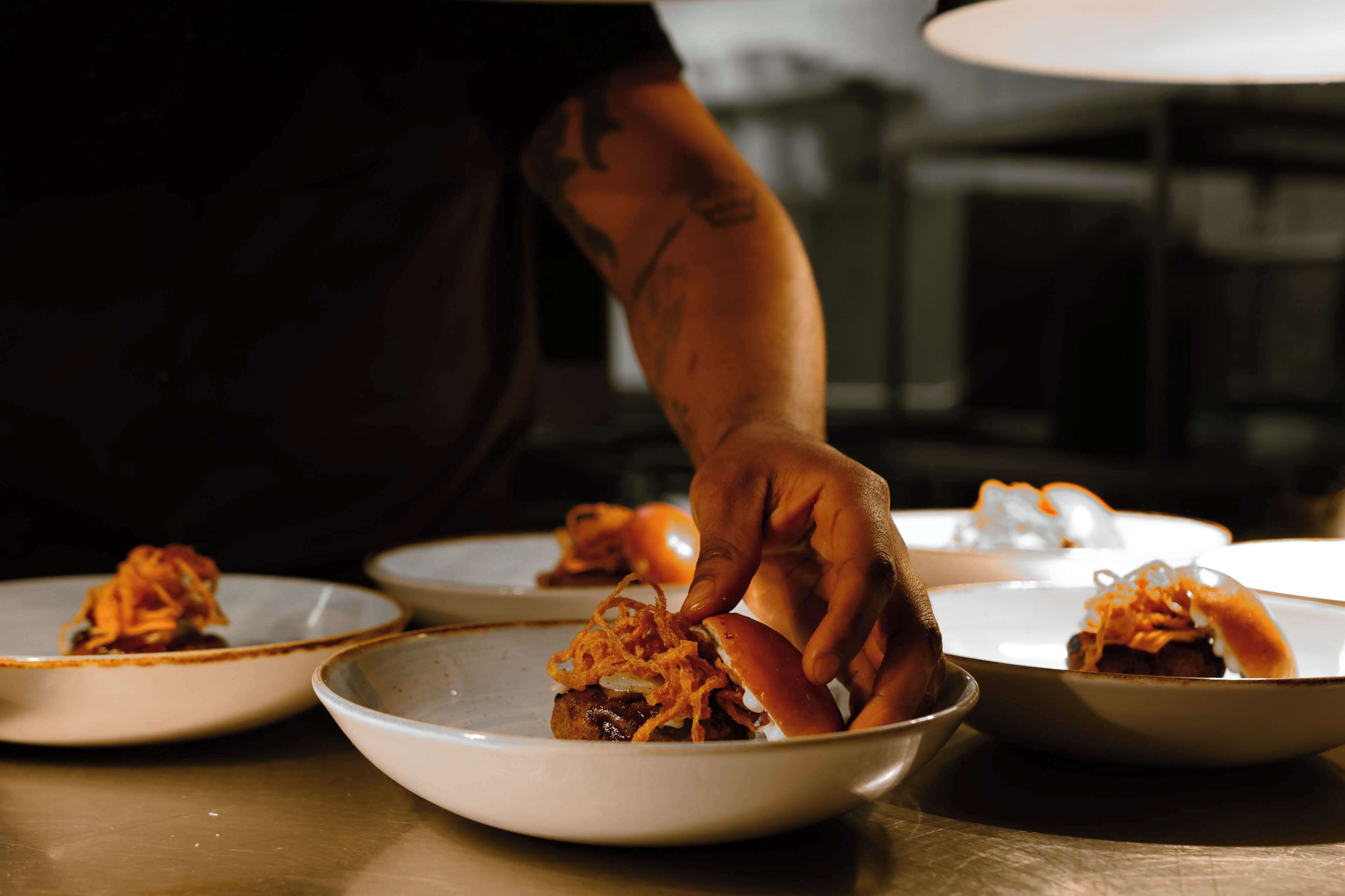 Iemand serveert eten op borden.