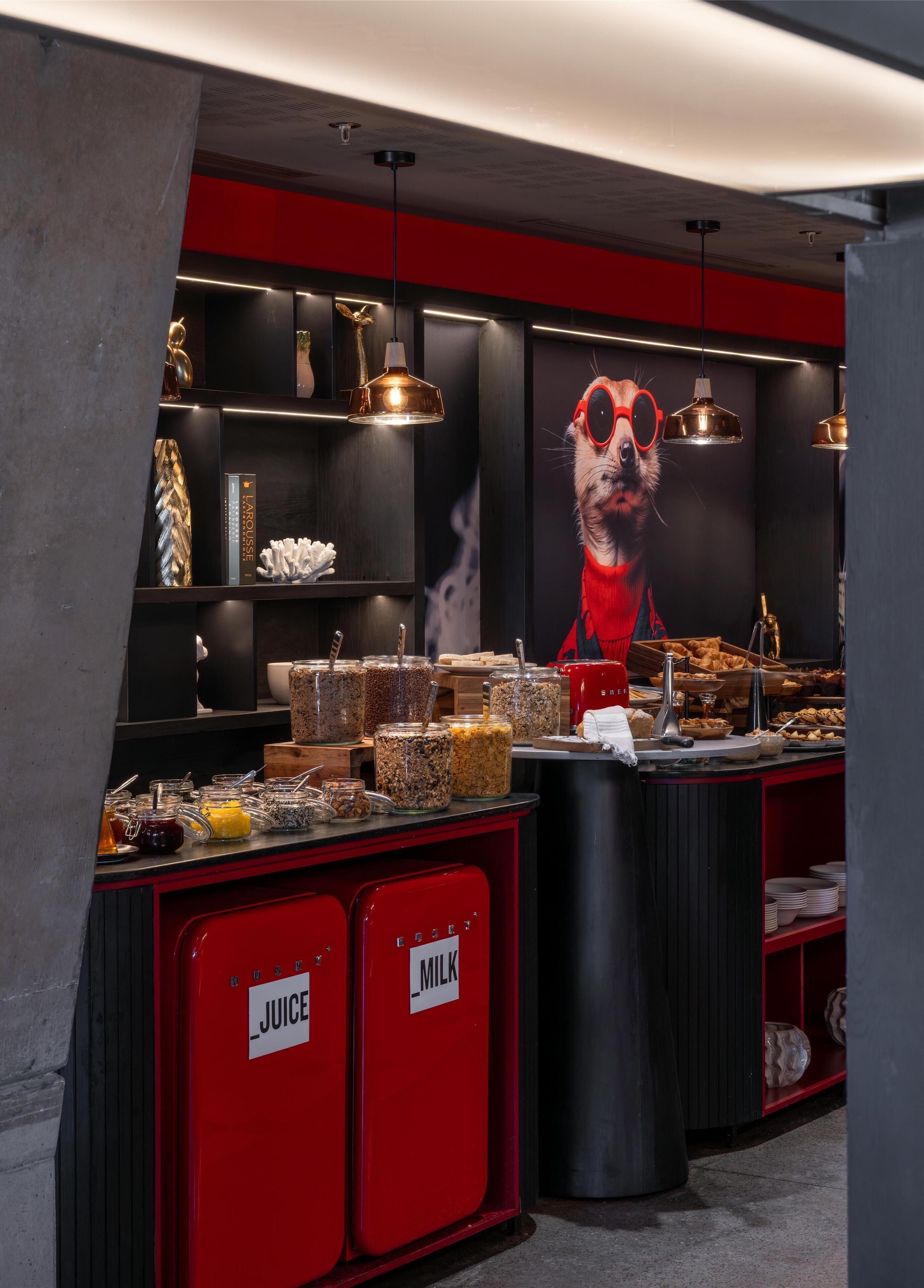 A breakfast bar with various food items and labeled milk and juice dispensers.