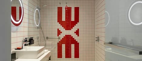 A modern bathroom with a tiled floor, a white sink, and a shower area.