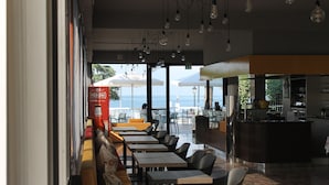 Un restaurante con terraza, una zona de bar y vistas al mar.