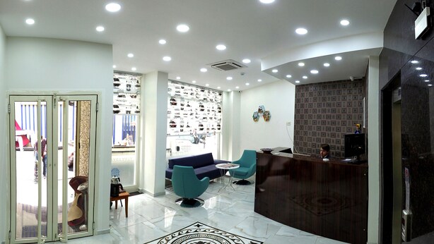 A hotel lobby with a reception desk, seating area, and a shoe display wall. - Kadikoy Arya Hotel (Istanbul)