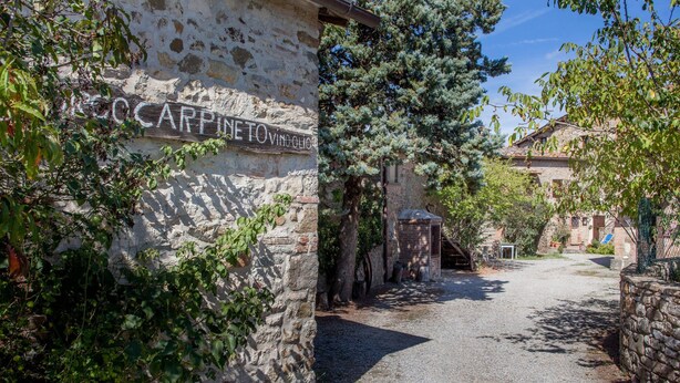 Un edificio rústico de piedra con un letrero que dice "CARPINETTO VINOLO".