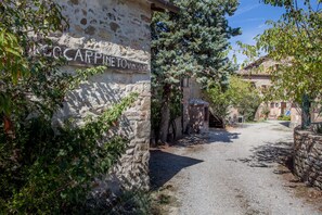 A rustic stone building with a sign reading "CARPINETTO VINOLO". - Borgo Carpineto (Castelnuovo Berardenga)