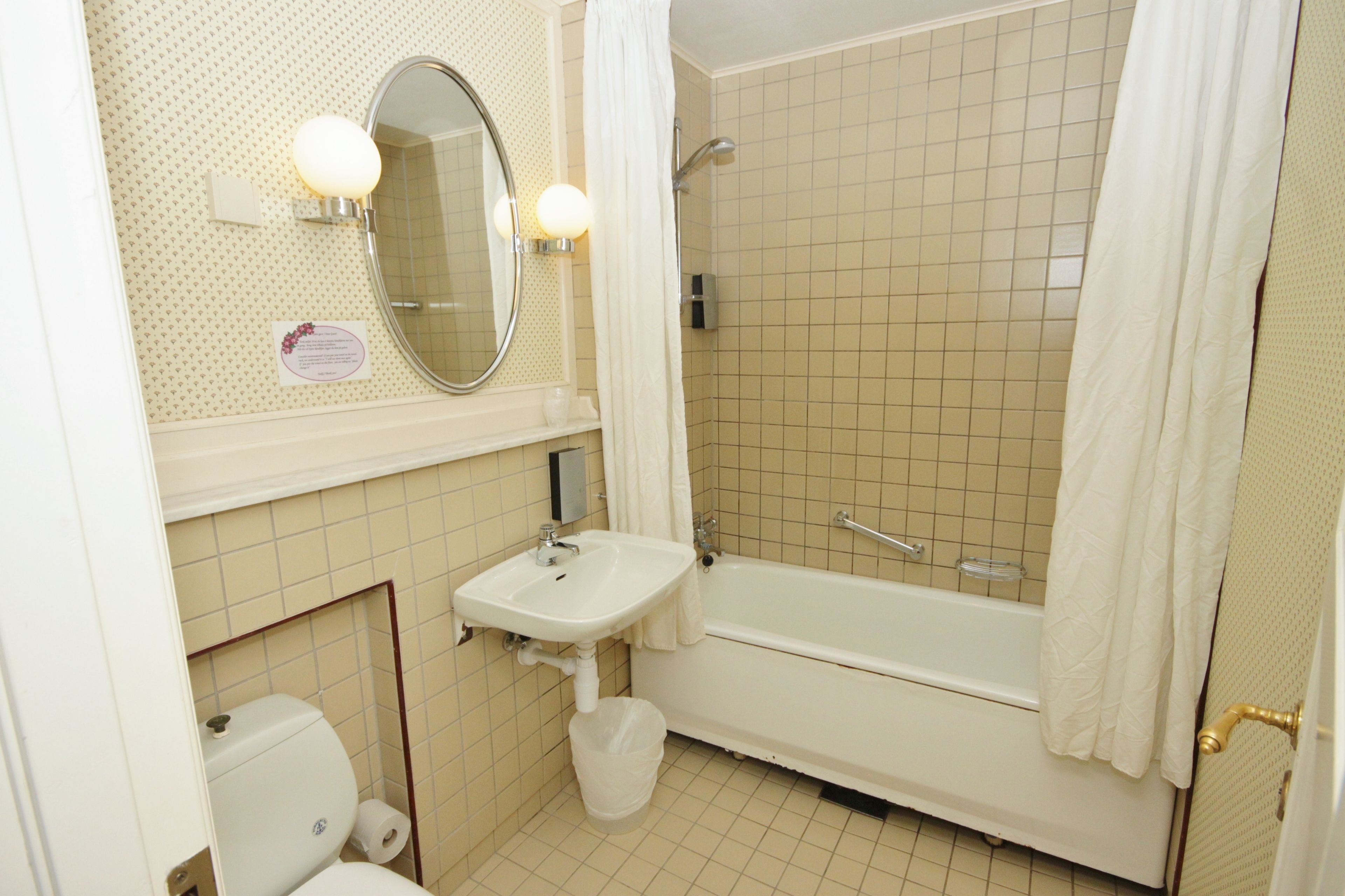 A bathroom with a toilet, sink, and bathtub.