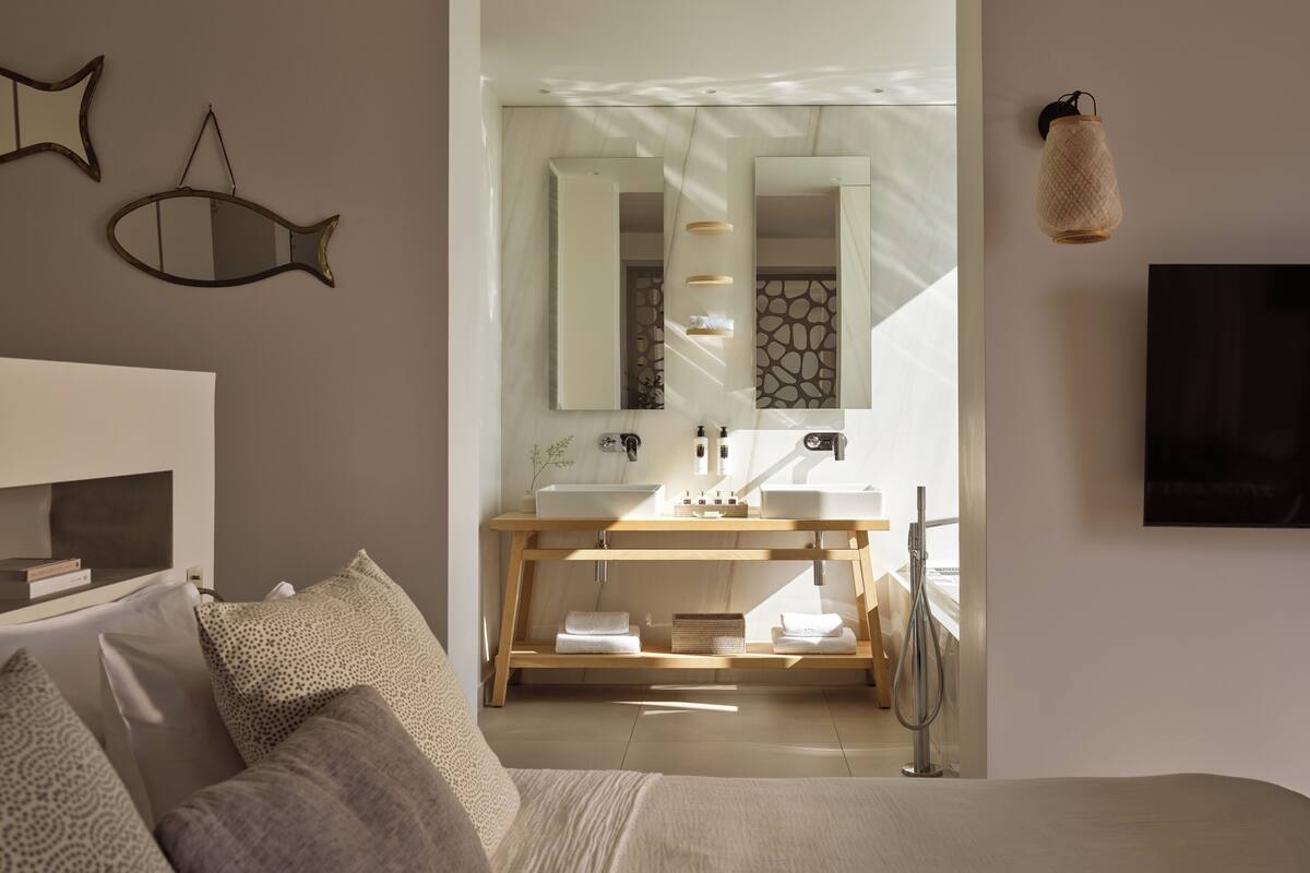 Ein modernes Badezimmer mit Waschtisch, Spiegel und Handtuchhalter.