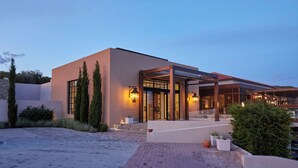 A modern building with a glass entrance, a covered outdoor area, and a paved walkway. - Eagles Villas - Small Luxury Hotels of The World (Aristotelis)