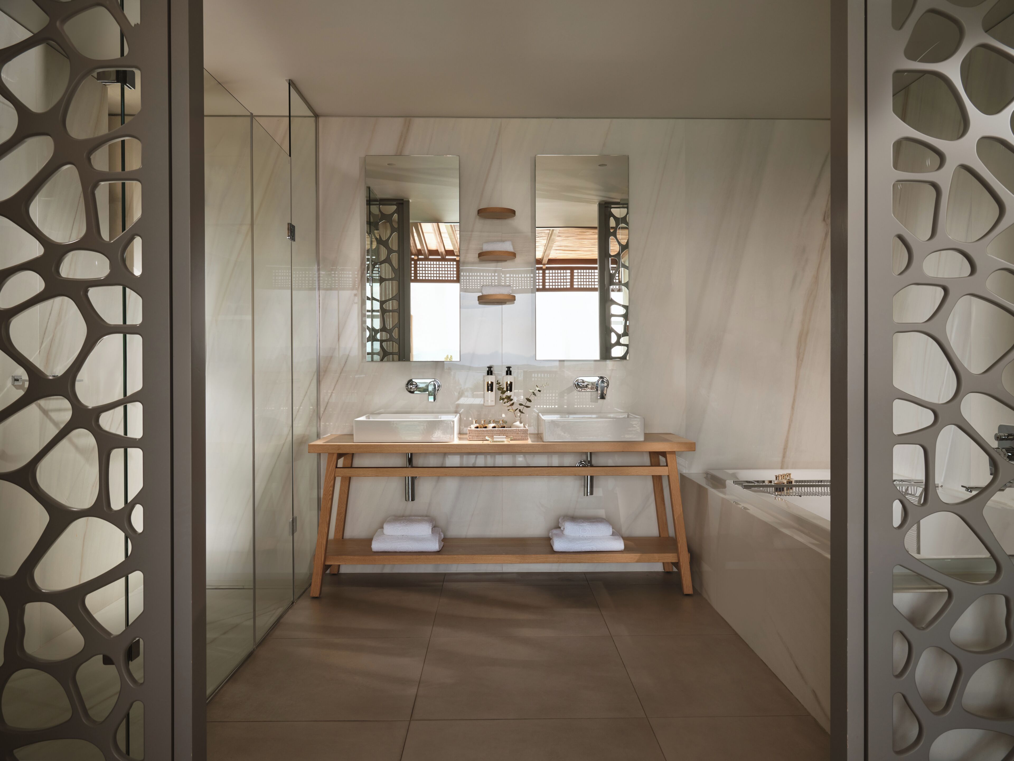 Une salle de bain moderne avec un meuble-lavabo en bois, deux vasques, un grand miroir et une baignoire.