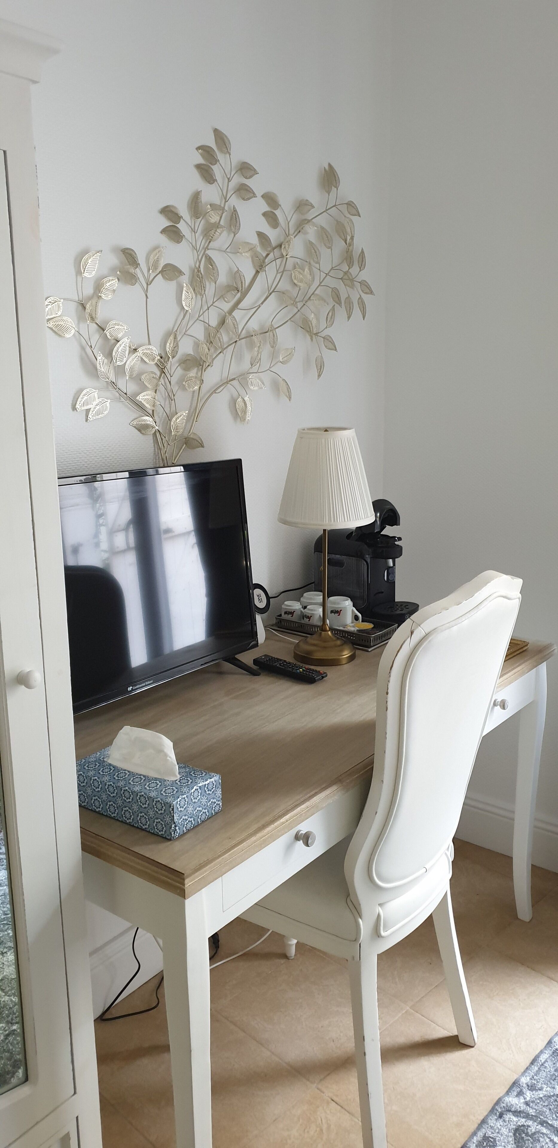 Un espacio de trabajo ordenado con una computadora portátil, una lámpara y una planta decorativa sobre un escritorio de madera.