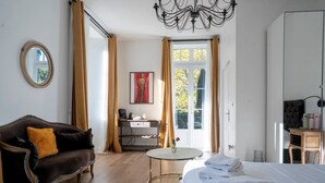 A hotel room with a bed, a sofa, a desk, and a chair. - Château Des Ayes (Saint-Etienne-de-Saint-Geoirs)