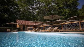 Una piscina al aire libre de temporada, sombrillas