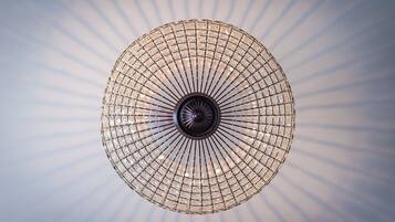 A circular chandelier with a grid pattern and a central light fixture.