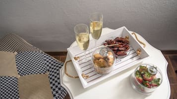 A tray with cookies, a glass of white wine, and a glass of rosé wine on a white table.