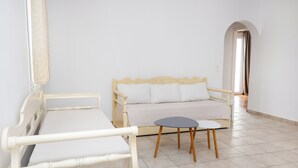 A room with a bed, a sofa, and a small table. - Depis Apartments 2 (Naxos)