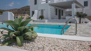 A modern white villa with a swimming pool, surrounded by pebbles and plants. - Depis Sea Side Villas (Naxos)