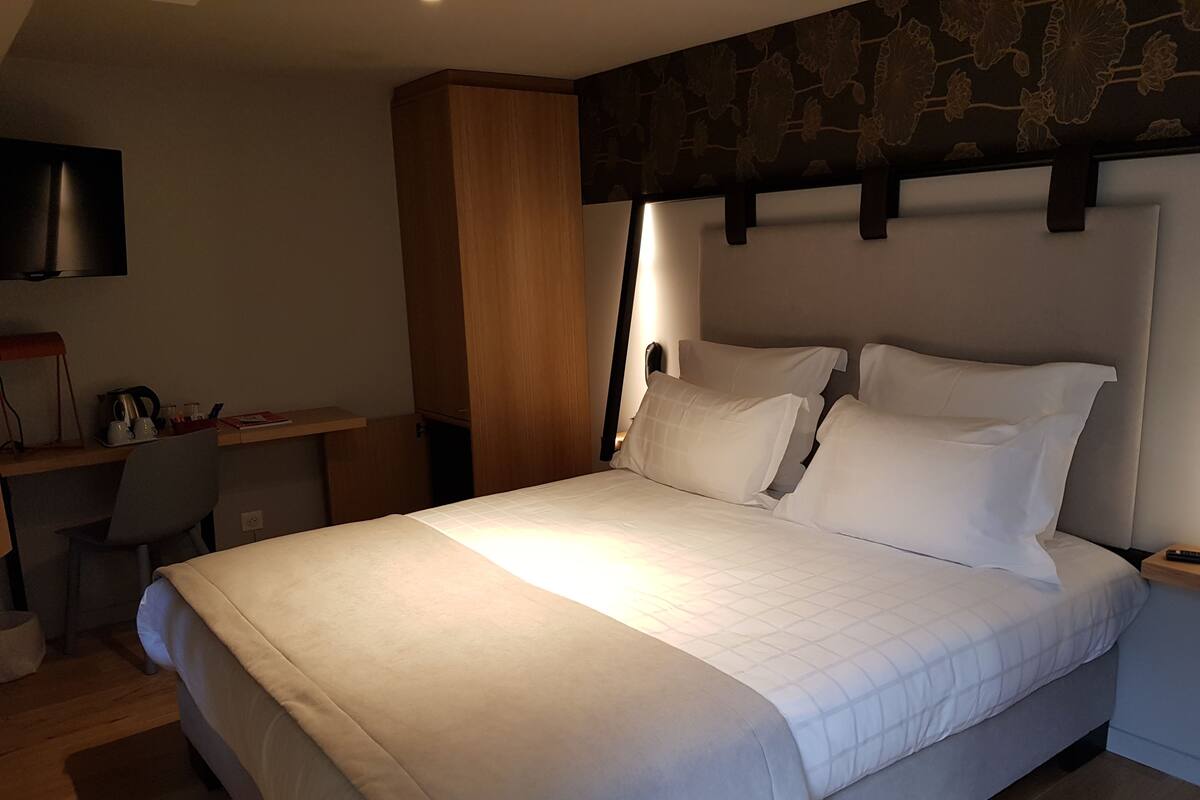 Un dormitorio con una cama grande, un escritorio y una silla.