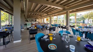 A spacious outdoor dining area with multiple tables and chairs, large windows, and a view of the outdoors. - Villa Nichesola (Colognola ai Colli)