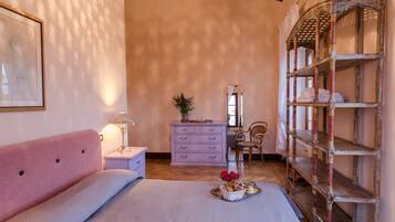 Une chambre à coucher comprenant un lit, une commode, une chaise, une étagère et un miroir.