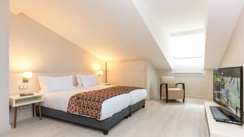 Une chambre d’hôtel moderne, dotée d’un grand lit, d’une télévision et d’un bureau.