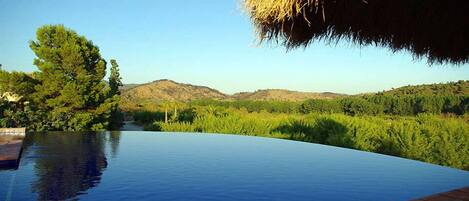 Utendørsbasseng,et evighetsbasseng, bassengparasoller og solsenger