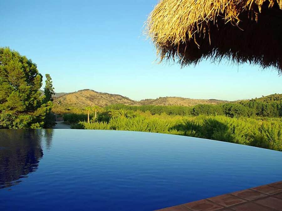 Outdoor pool, an infinity pool, pool umbrellas, sun loungers