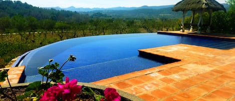 Outdoor pool, an infinity pool, pool umbrellas, pool loungers