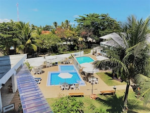 A rooftop pool area with multiple seating arrangements and a clear view of the surrounding landscape. - Vivenda dos Arrecifes (Ipojuca)