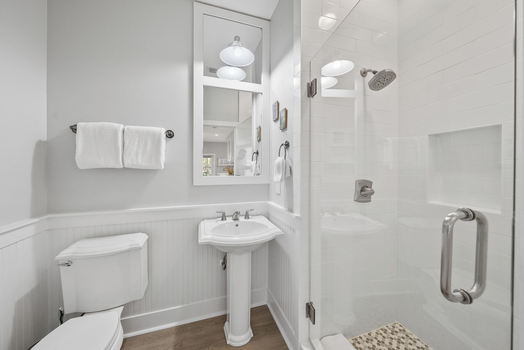 A modern bathroom with a toilet, sink, and walk-in shower.