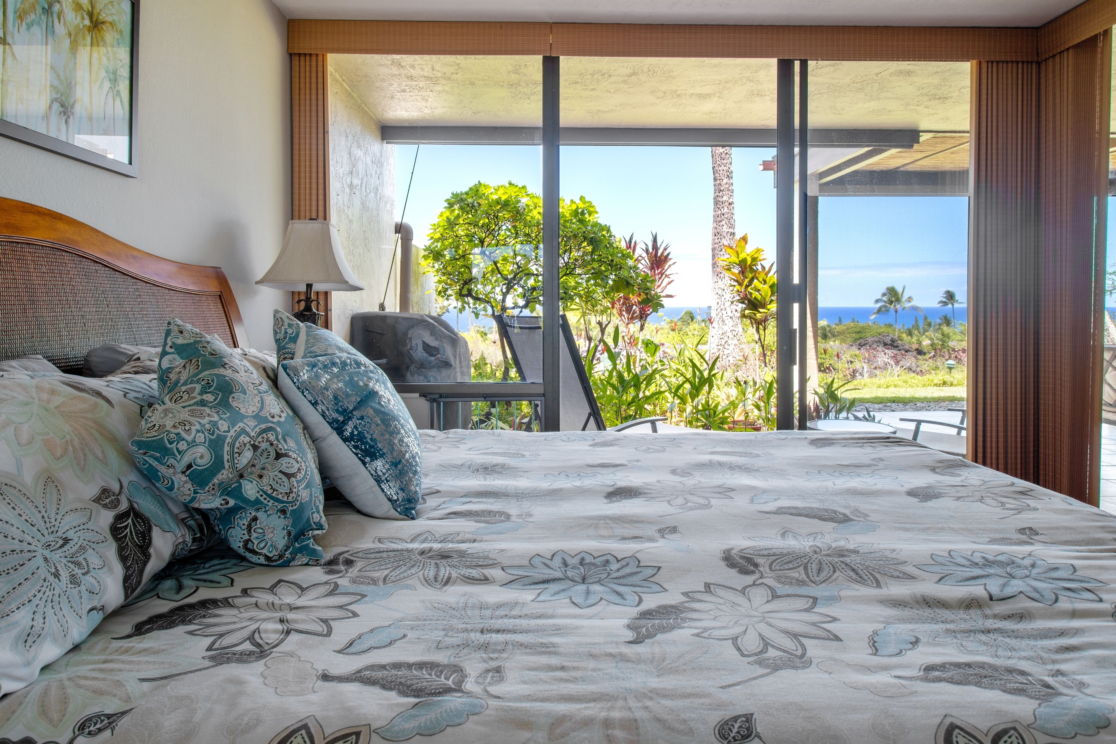 Quarto com uma cama grande, vista para o exterior e uma janela com cortinas.