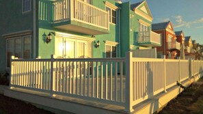 A two-story house with a balcony, a white fence, and a porch. - 'Sunset Vista' - Negril Seafront Townhouse - W/Solar Power (Negril)
