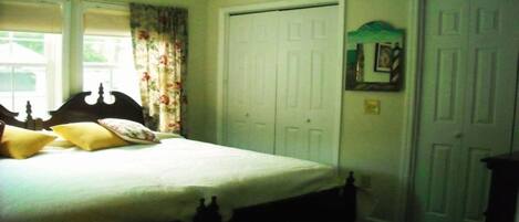 Une chambre à coucher avec un lit, une armoire et un miroir au mur.
