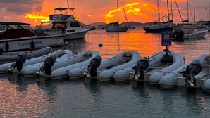 Un port de plaisance où sont amarrés des bateaux et des radeaux gonflables.