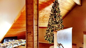 Ein Loft-Zimmer mit Holzboden, einem Weihnachtsbaum und einem Kicker.