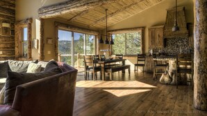 A rustic cabin interior with a wooden dining table, chairs, and a sofa. - Views! Space! Featured on CBS Staycation Luxury Big Bear Pool Table & Theater (Big Bear Lake)