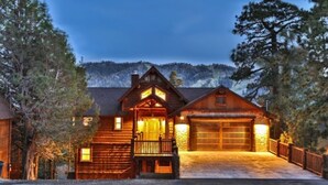 A log cabin with a front porch, a garage, and a mountain backdrop. - Views! Space! Featured on CBS Staycation Luxury Big Bear Pool Table & Theater (Big Bear Lake)