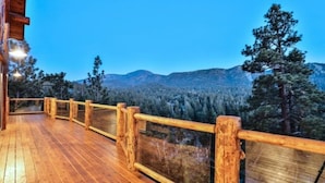 A wooden deck with a railing overlooking a forested mountain range. - Views! Space! Featured on CBS Staycation Luxury Big Bear Pool Table & Theater (Big Bear Lake)