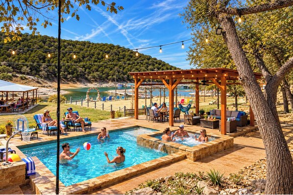 Uma área de piscina com pergolado, espreguiçadeiras e vista para a praia.