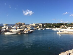 A marina with boats docked, buildings in the background, and a clear sky. - Stunning 40m2 Rooftop terrace with private jacuzzi and fantastic sea views! (Marbella)