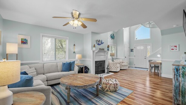 A spacious living room with a sofa, coffee table, and a fireplace.
