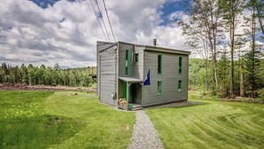 A two-story house with a gravel driveway and a green lawn. - Reillys Rest-private home in Green Mtns, kid-pet friendly-Ski,Bike,Walk,Relax! (Weston)