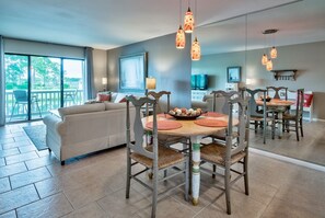 A dining area with a round table, chairs, and hanging pendant lights. - Casual, clean, comfy, beautiful views. Golf cart with agreement. Love your stay. (Miramar Beach)