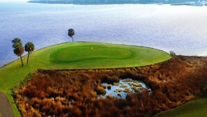 Un parcours de golf avec une étendue d'eau en arrière-plan.