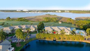 A residential area with houses, a golf course, and a large body of water. - Casual, clean, comfy, beautiful views. Golf cart with agreement. Love your stay. (Miramar Beach)